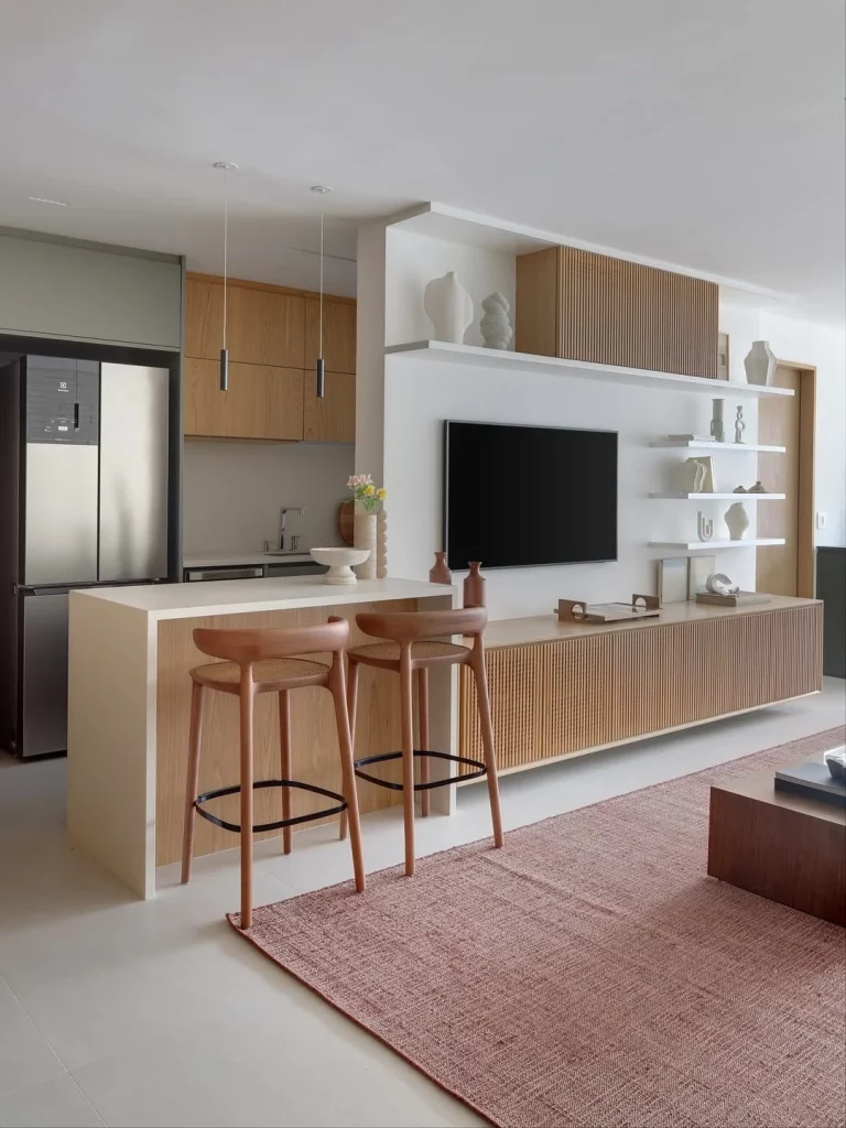 Cozinha e sala integrada com madeira em destaque ligando os dois ambientes.