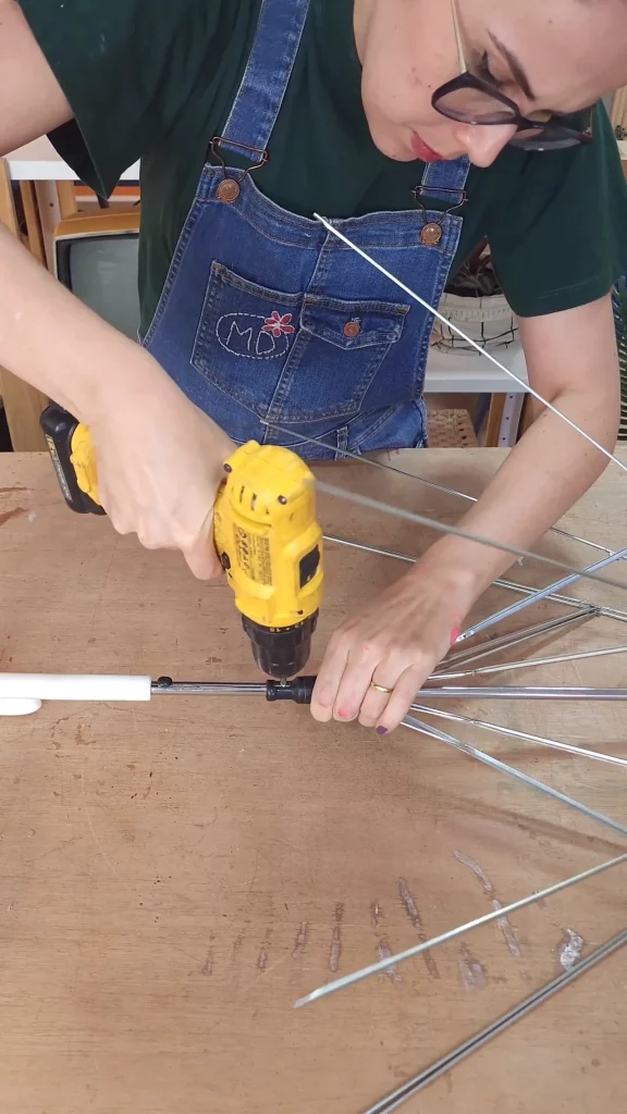 Instalação da trava no cabo do guarda-chuva com uma parafusadeira e parafuso.
