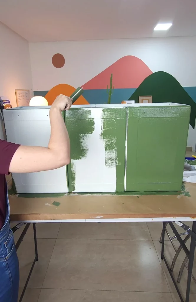 Pintando o armário antigo com tinta verde musgo.