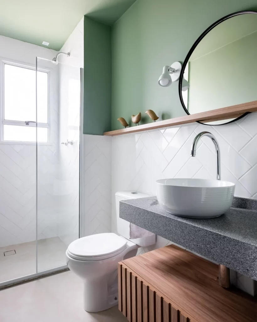 Prateleira de madeira perto do espelho e com esculturas de pássaros em cima.