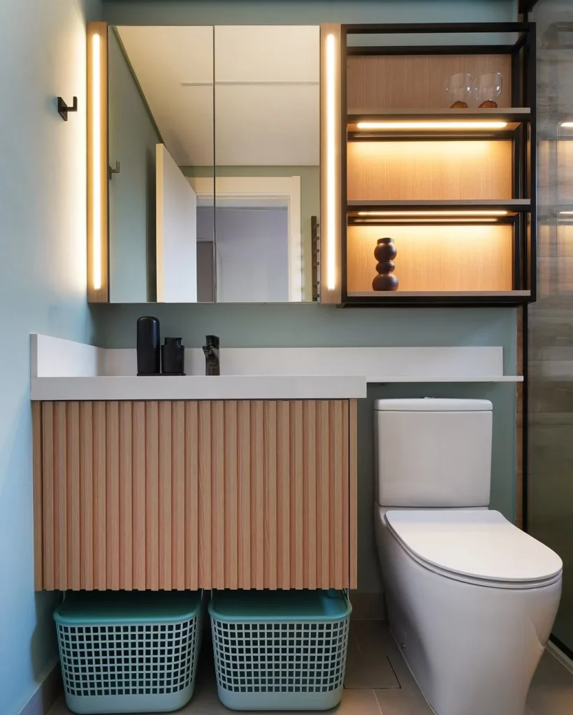 Prateleira iluminada ao lado do espelho e armário ripado.