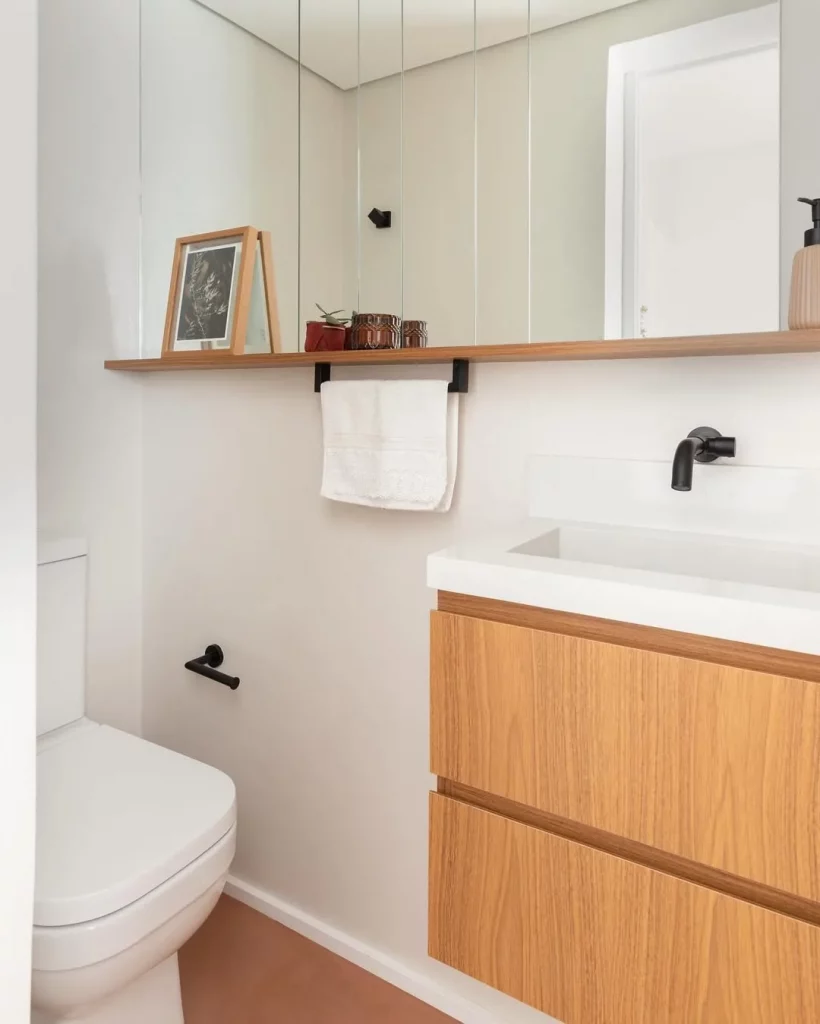 Prateleira no espelho e com suporte para toalha.