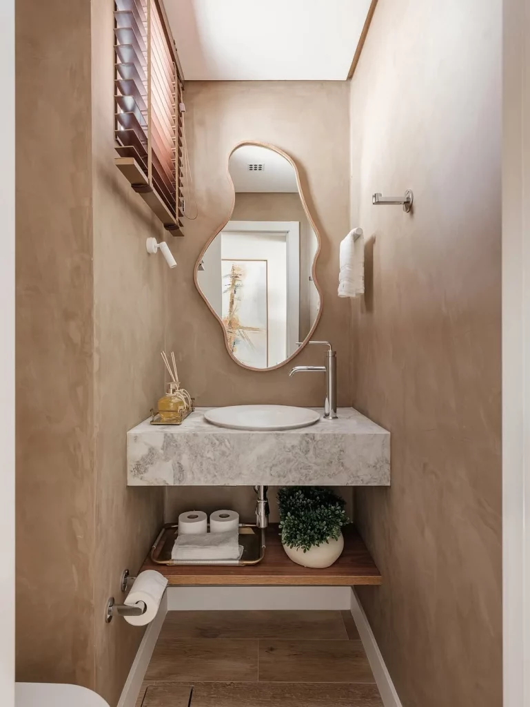 Prateleira organizada de madeira, com toalhas e papel higiênico.