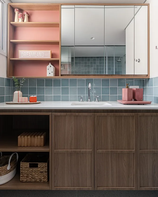 Prateleira ao lado do espelho com fundo rosa.