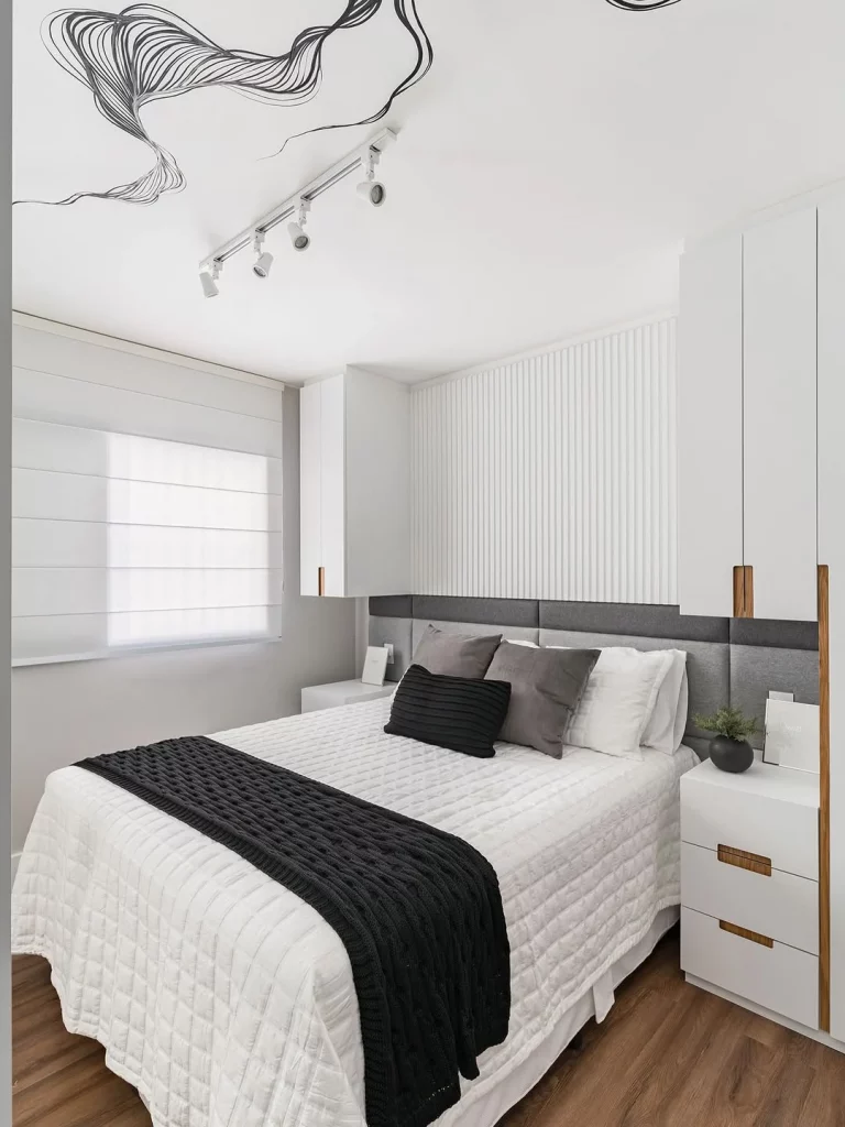 Quarto minimalista com detalhes chamativos em preto.