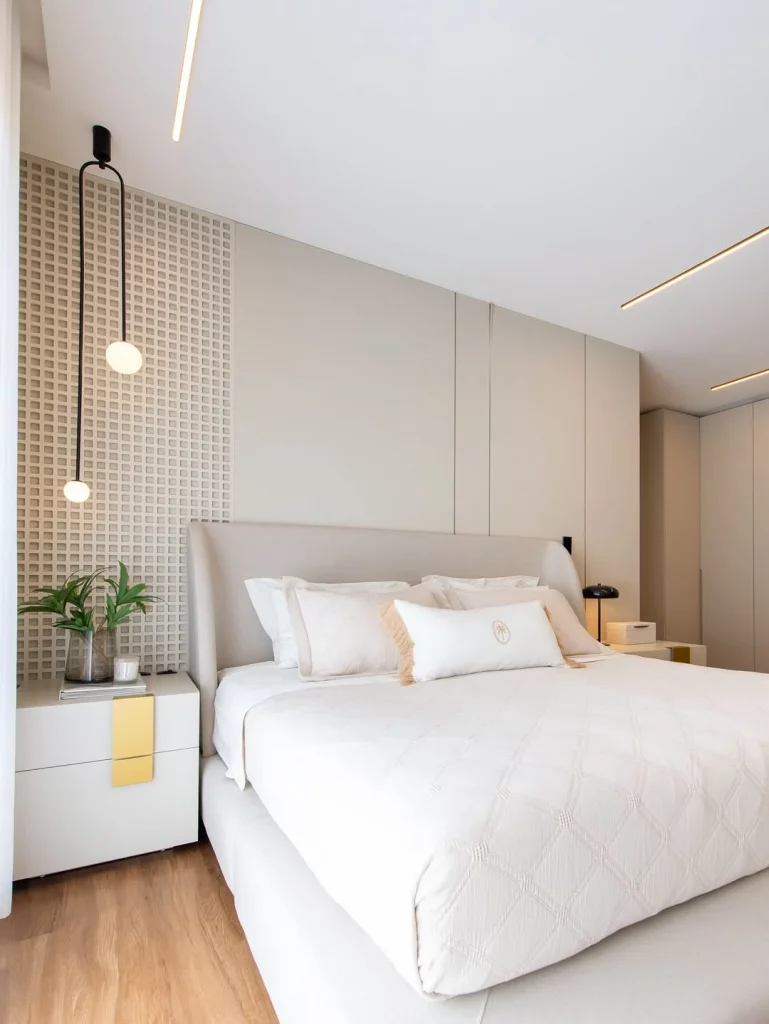 Paredes texturizadas no quarto minimalista e cores claras que trazem elegância.