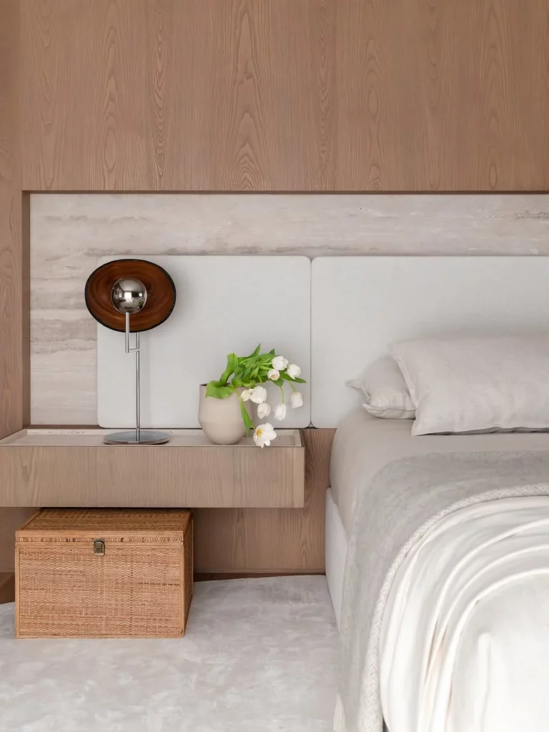 Parede de madeira com duas cabeceiras na cama.