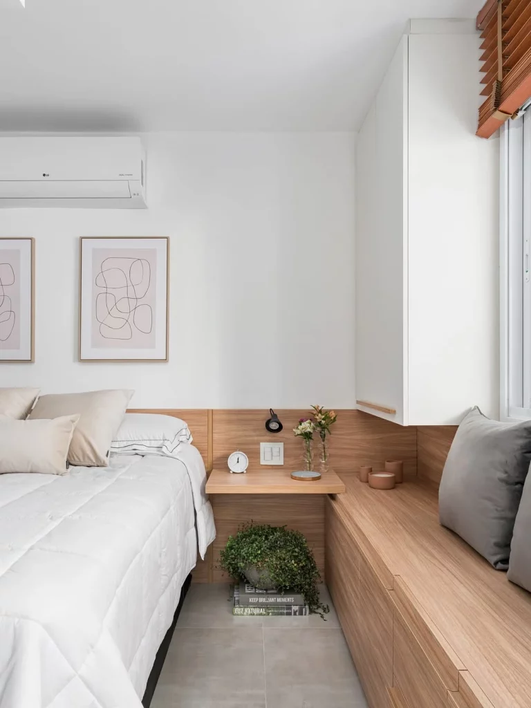 Quarto com detalhes de madeira e quadros absstratos.