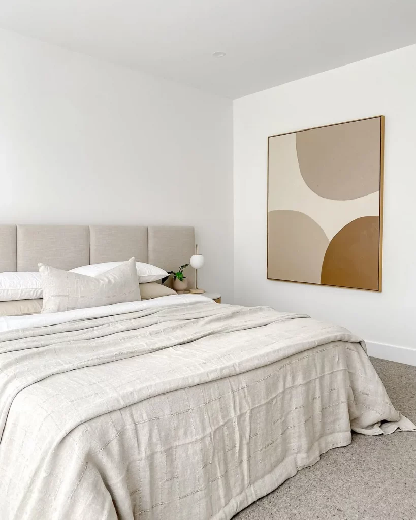 Quarto minimalista com quadro grande chamativo.