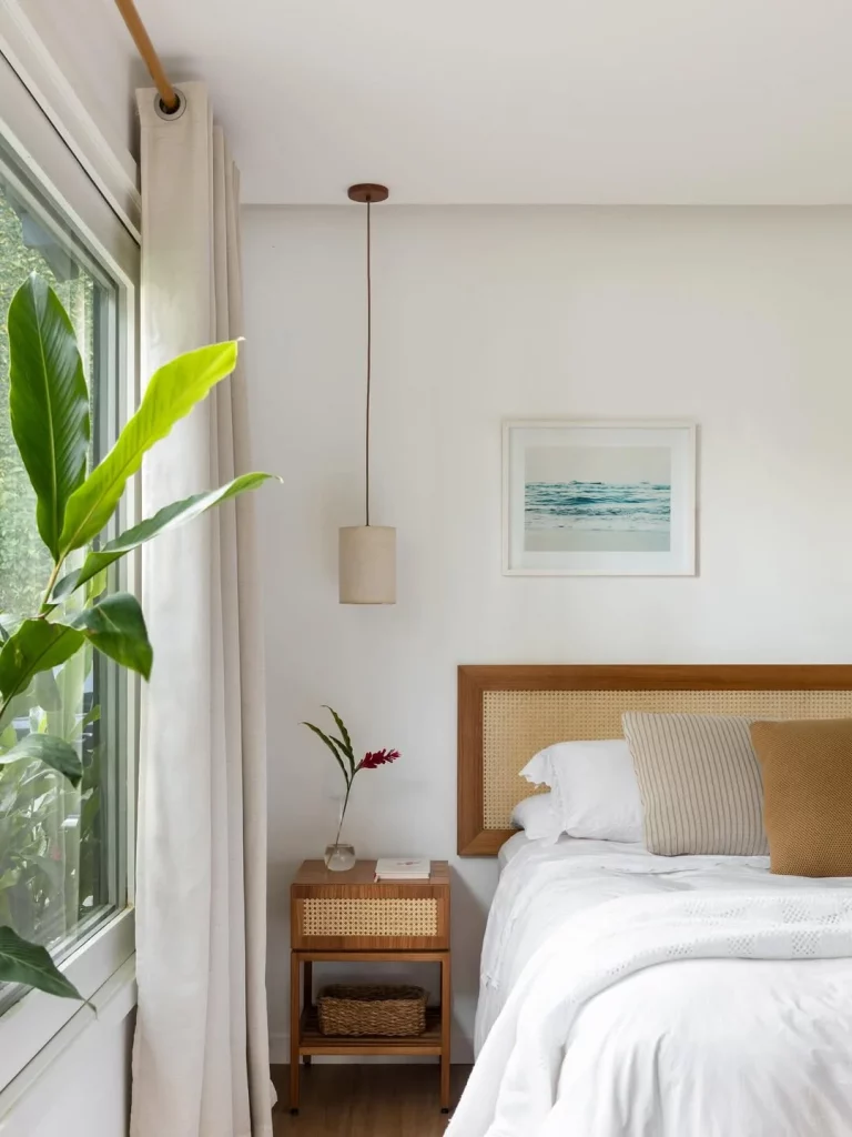 Cabeceira com palha indiana e roupa de cama branca.