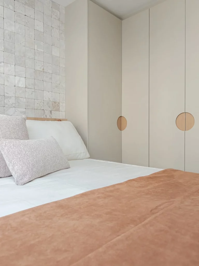 Quarto delicado com tons claros e guarda-roupas cinza.