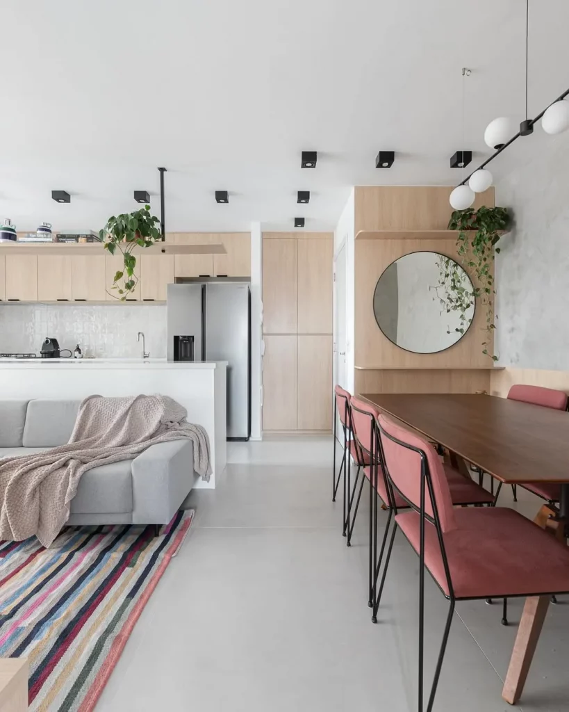 Sala de estar com elementos coloridos e piso neutro.