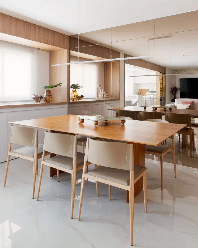 Painel de espelho na sala de jantar que reflete na sala de estar.