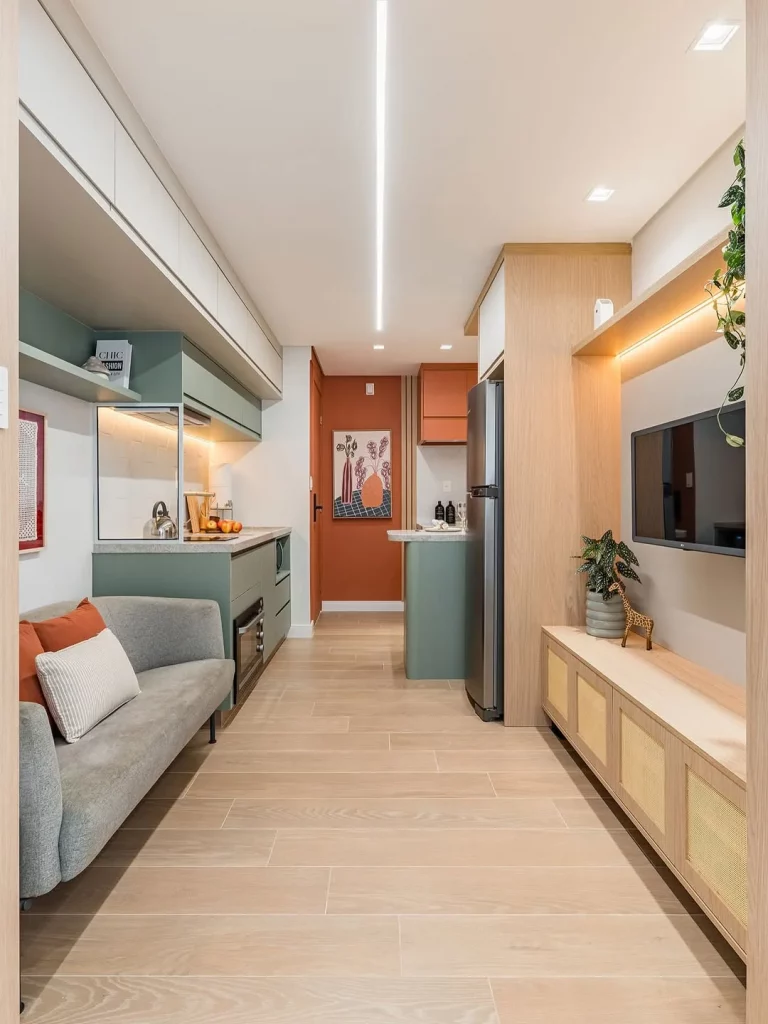 Opção de cozinha e sala conjugada em layout linear, armários coloridos e objetos de madeira.