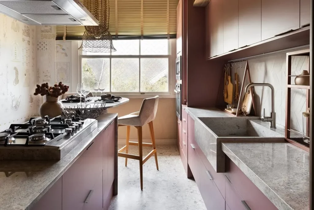 Bancada de mármore cinza com armário de cozinha rosa.