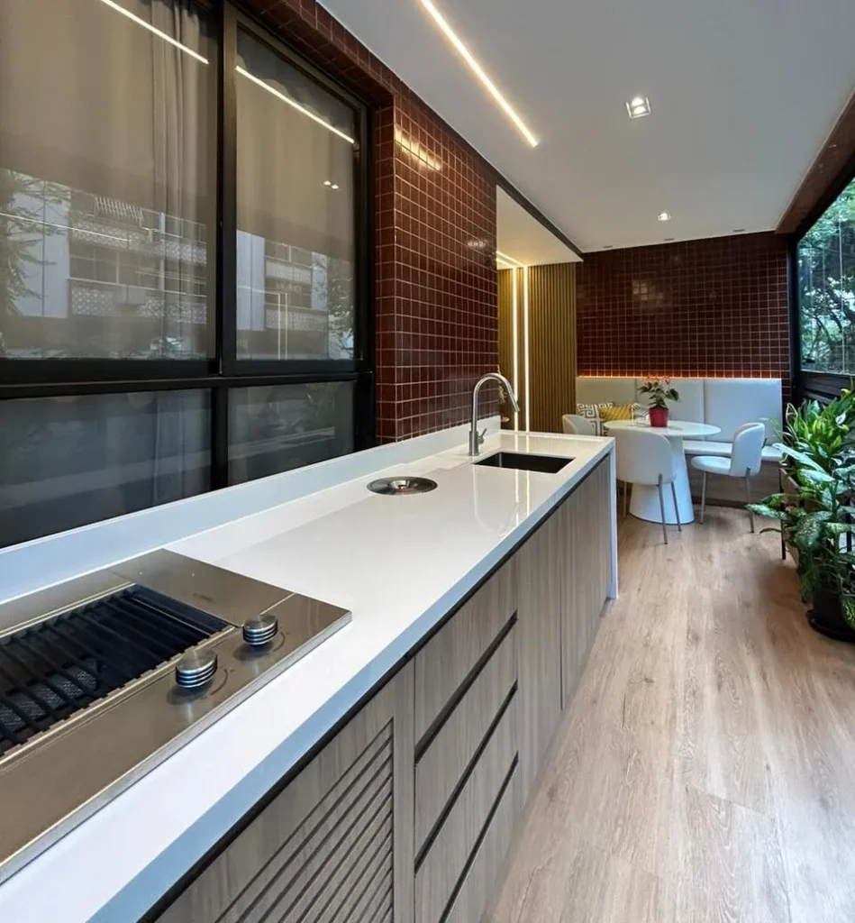 Bancada de cozinha com detalhes nela, como lixeira embutida.