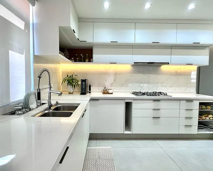 Cozinha espaçosa com pia de mármore branco.