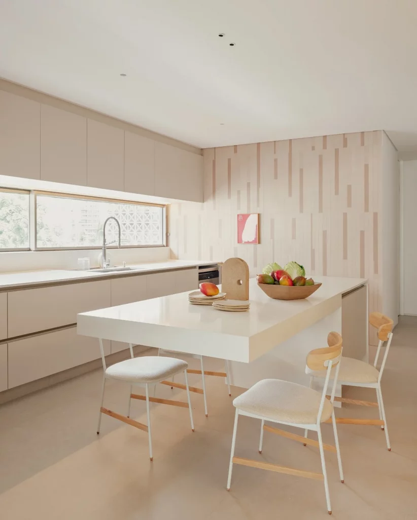 Cozinha com bancada branca e visual bem clean.