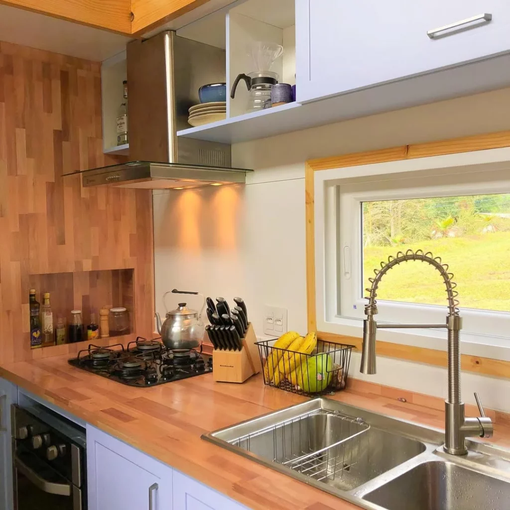 Bancada de cozinha com pia dupla e feita de madeira.