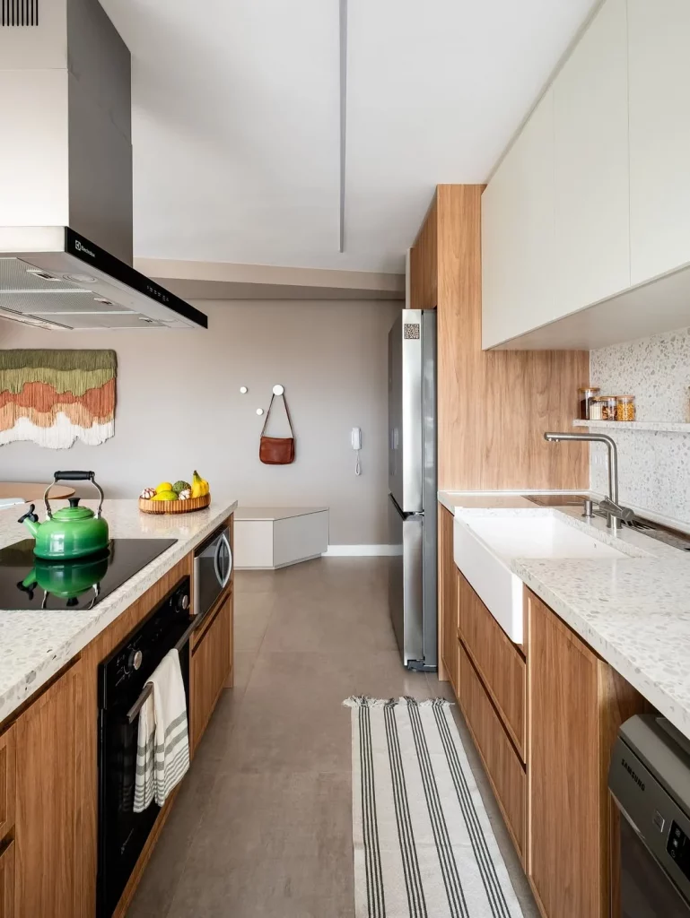 Cozinha com bancadas estreitas e armários de madeira.