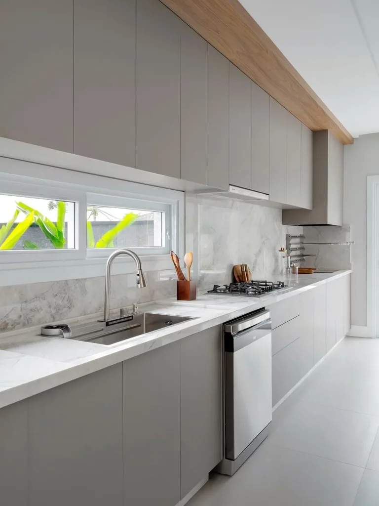 Cozinha com bancada clean e armários cinza.