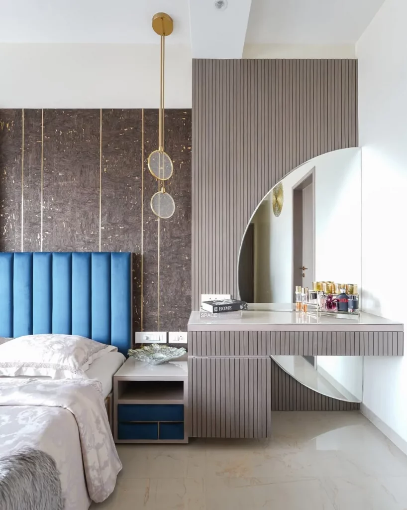 Penteadeira com espelho meia lua e parede cinza.