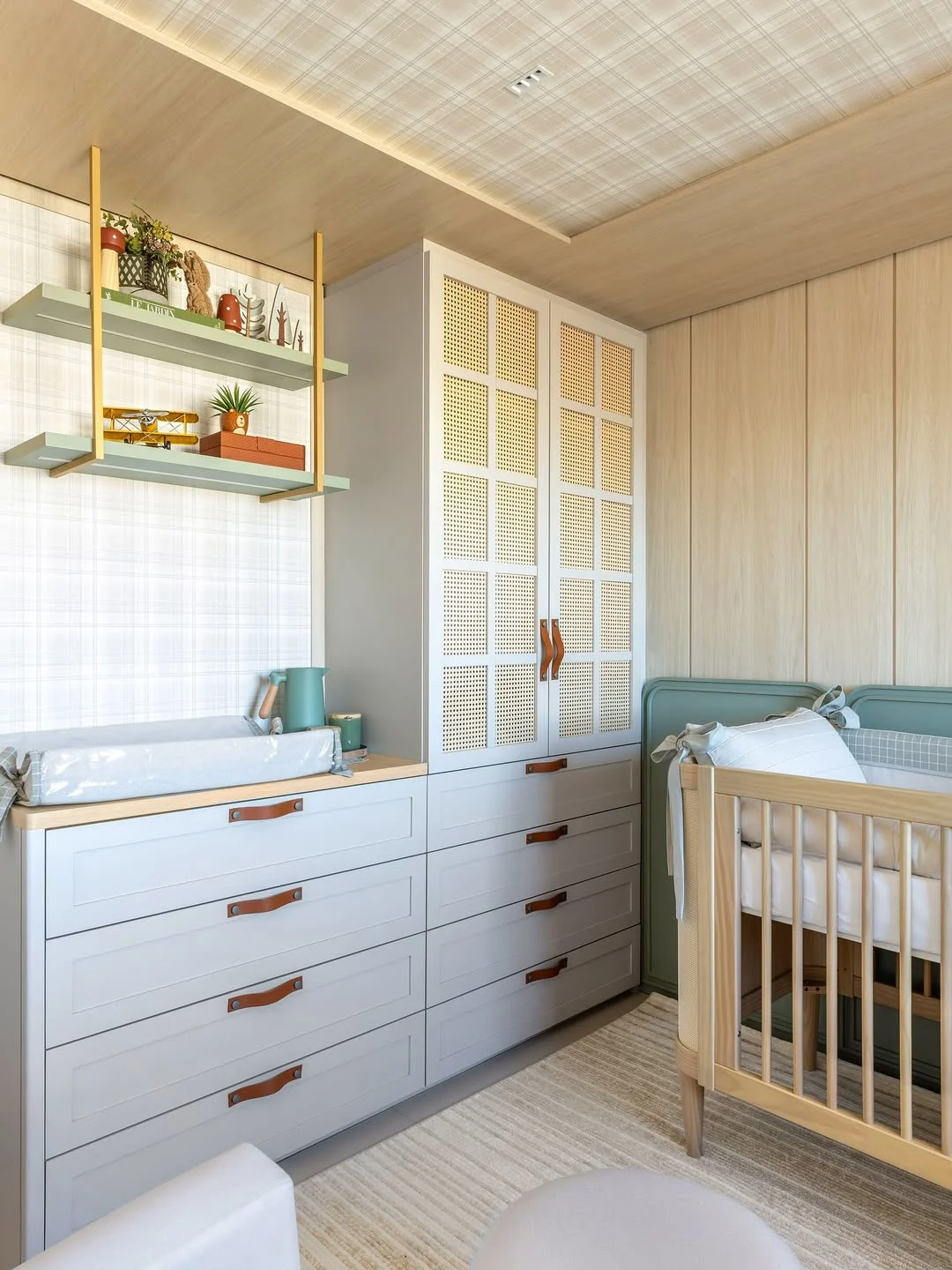 Quarto de bebê com guarda-roupa e cômoda em um só, prateleira na parede.