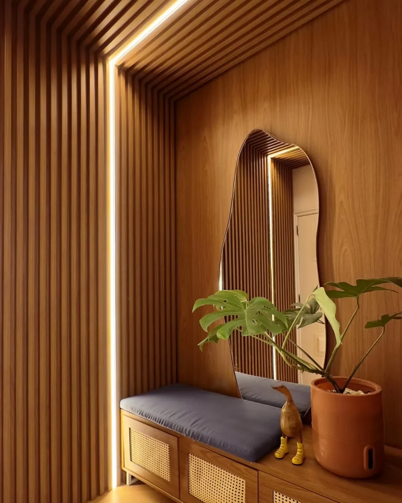 Hall de entrada com banco e espelho orgânico.