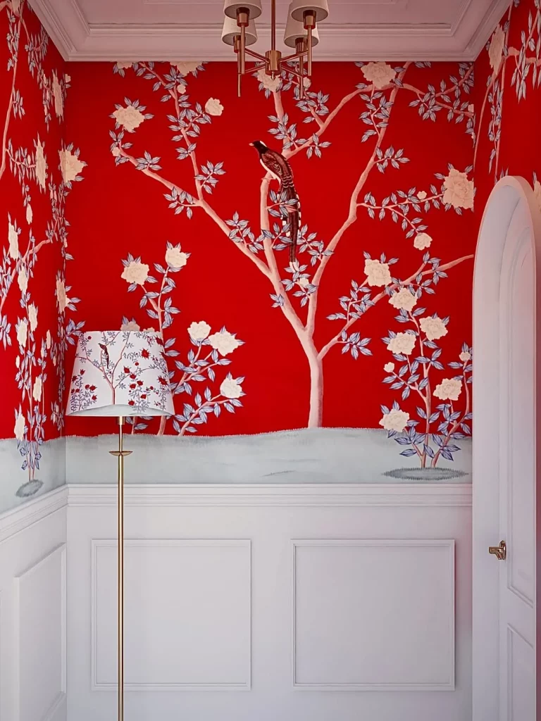 Hall de entrada com papel de parede vermelho estampado, abajur estampado e metade da parede branca.