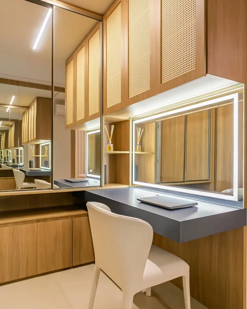 Penteadeira com iluminação artificial e espaço de home office junto, mesa cinza.