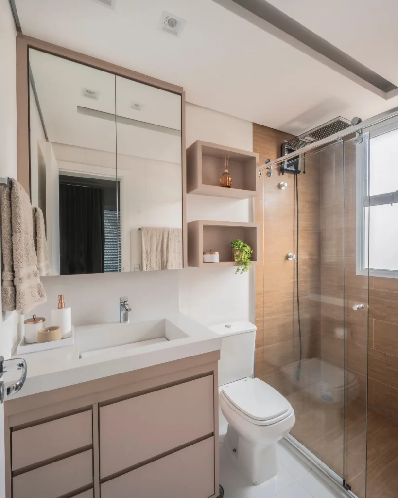 Nicho flutuante no banheiro na cor rosé, paredes de madeira no box.