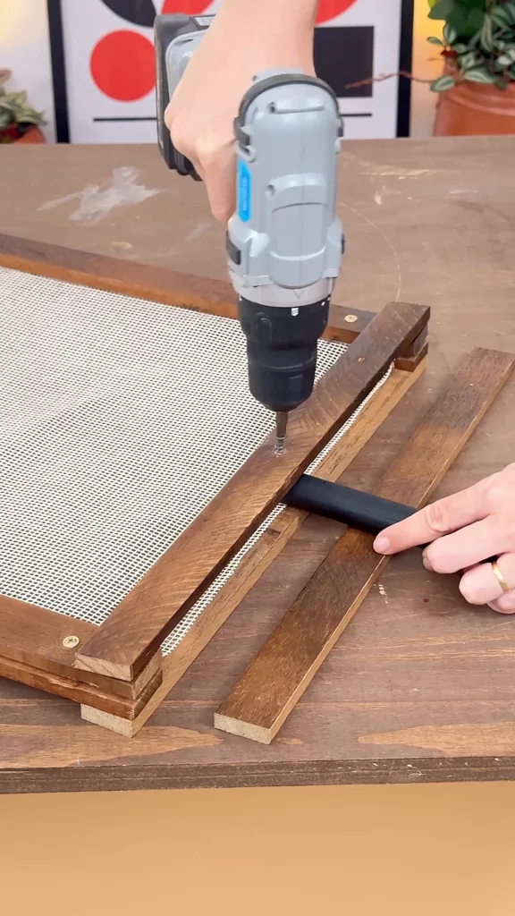 Instalando o cabo de vassoura entre as molduras.