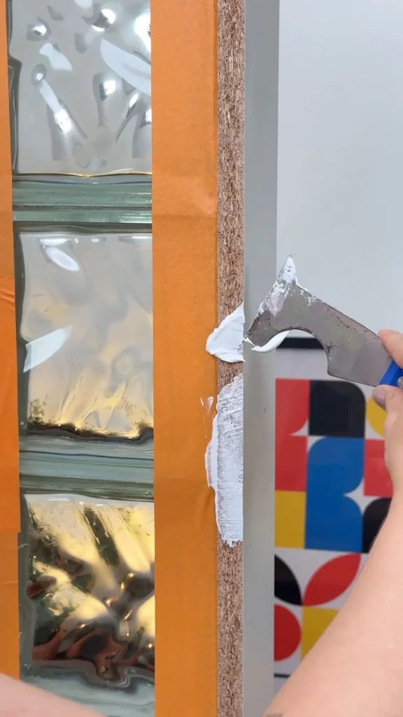 Passando massa corrida nas laterais da porta de guarda-roupa.