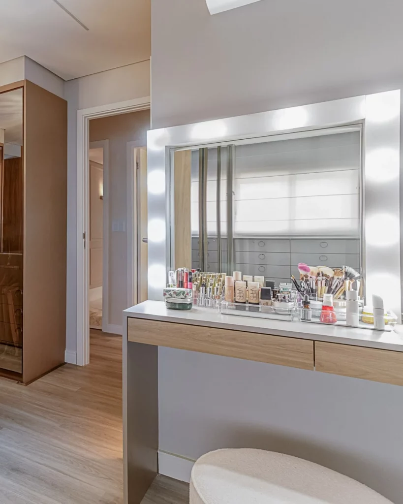 Penteadeira camarim com gavetas de madeira e iluminação branca.