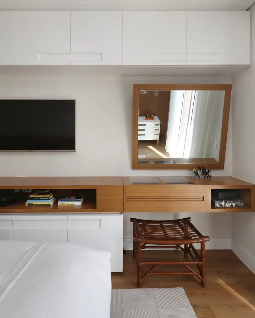 Penteadeira na sala com espelho tombado para frente na diagonal.