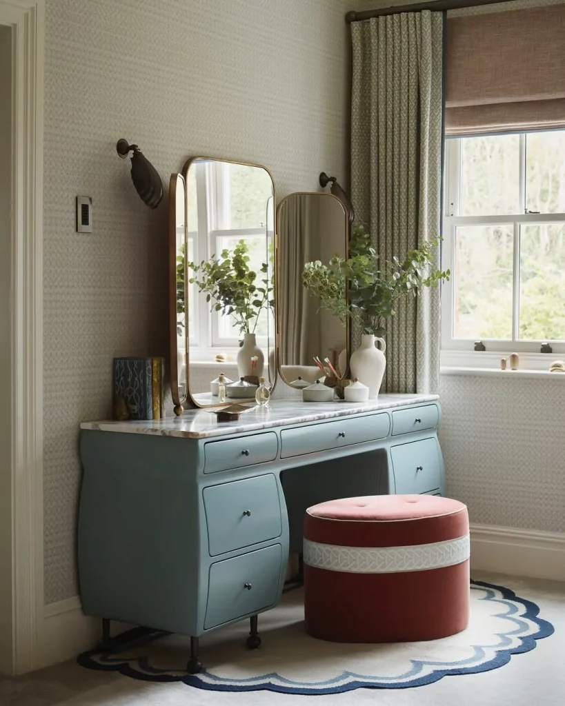 Penteadeira azul com muitas gavetas e espelho de abrir.