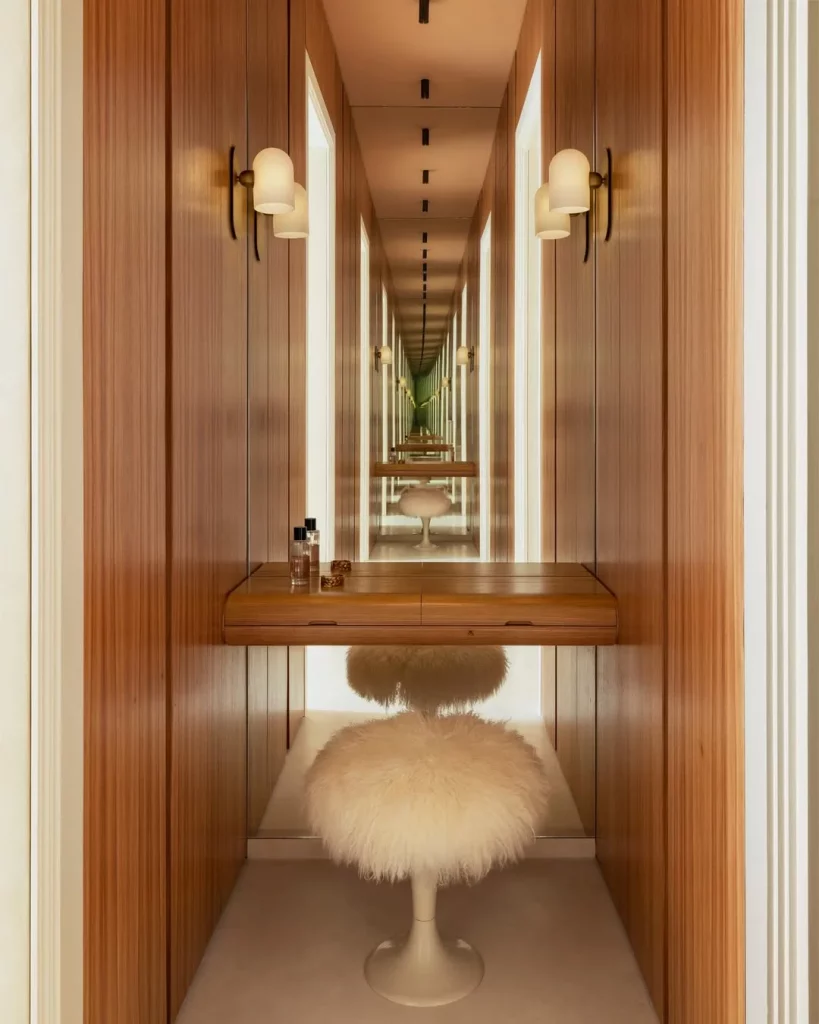 Penteadeira num canto estreito com puff felpudo.