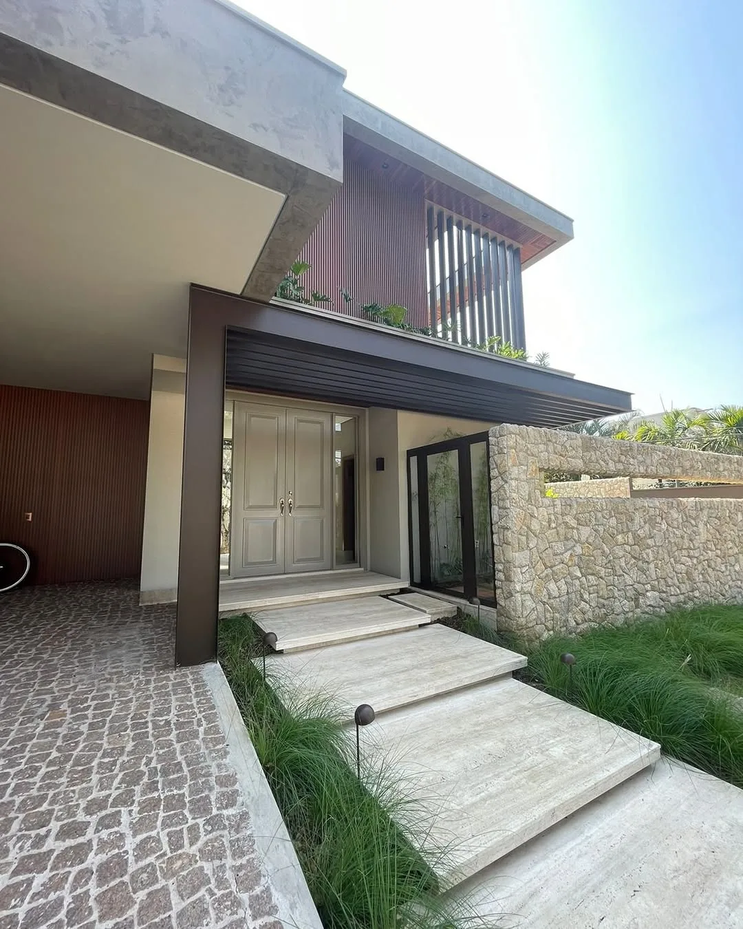 Pergolado marrom na fachada de casa elegante.