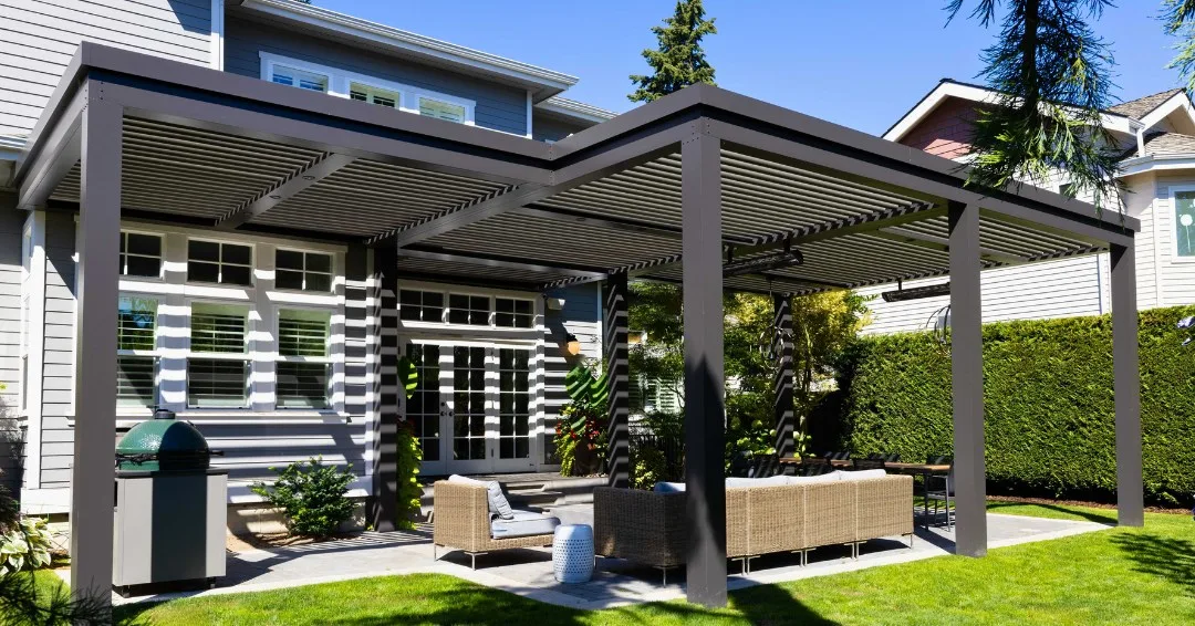 Pergolado elegante de ferro preto no jardim, grama e móveis claros.