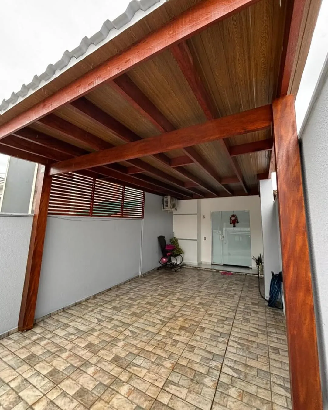 Pergolado de madeira como garagem de casa.
