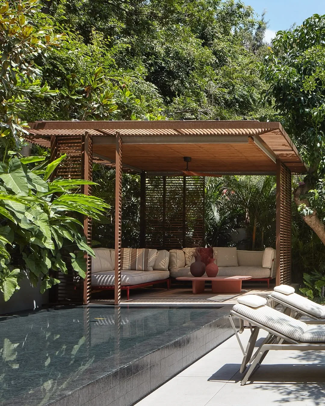 Pergolado de madeira elegante perto da área da piscina.