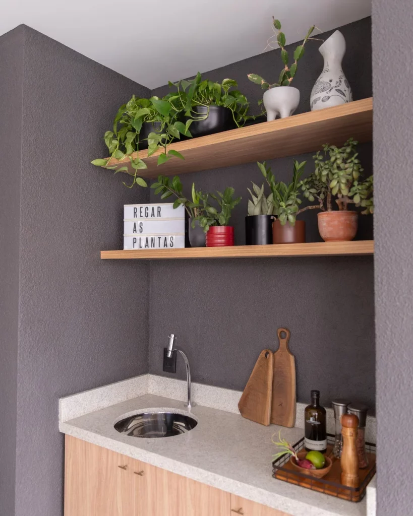 Prateleira de madeira com muitas plantas na área de serviço. 