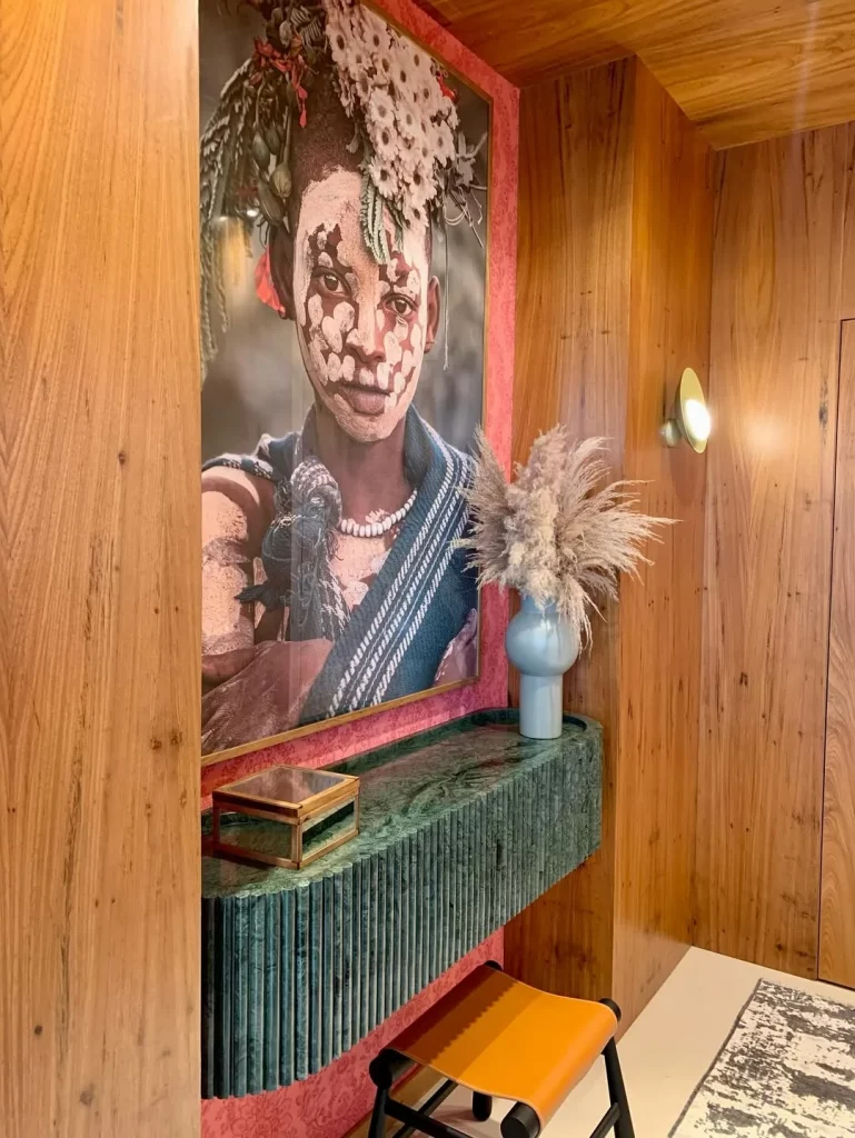 Hall de entrada com paredes de madeira e quadro grande na parede.