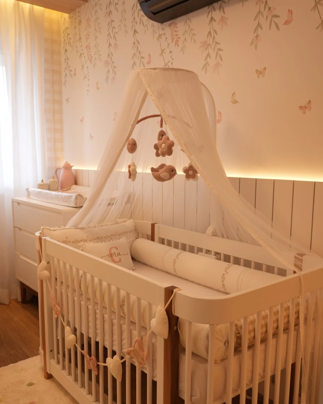 Quarto de bebê com iluminação amarelada.