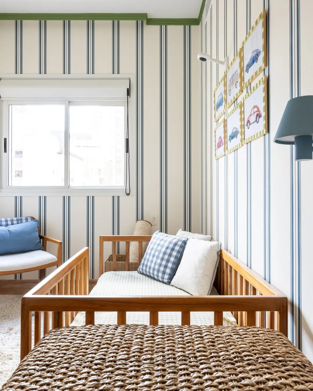 Quarto de bebê com paredes listradas.