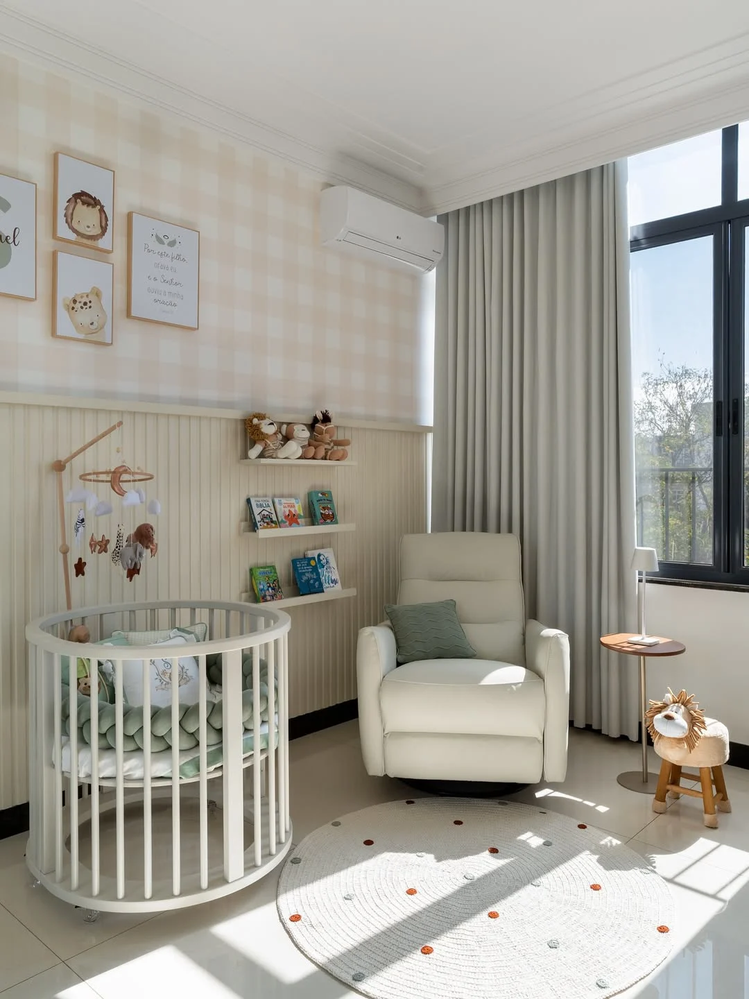 Quarto de menino com tema de safari nas paredes, poltrona de amamentação branca, papel de parede xadrez claro.