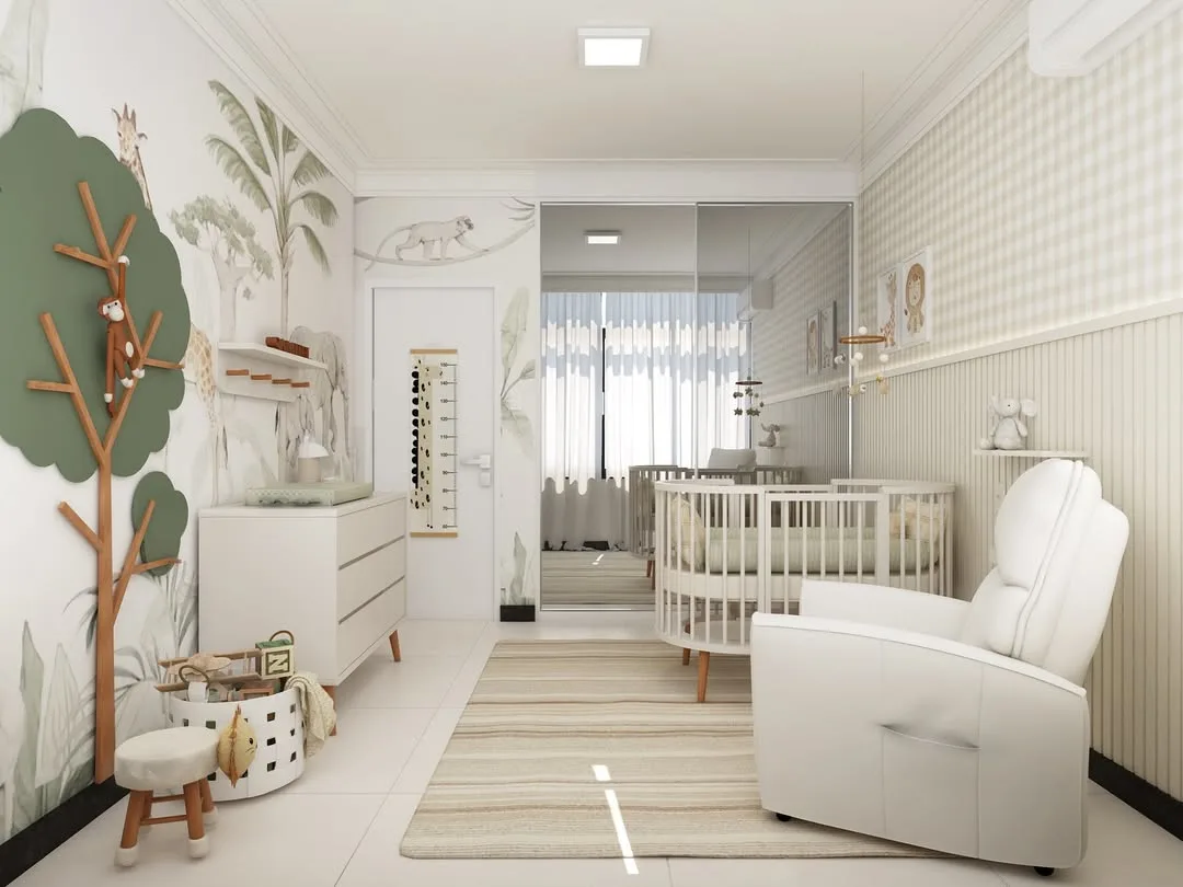 Quarto infantil com branco predominante, tema de safari nas paredes, poltrona branca e berço branco.
