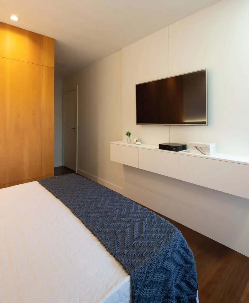 Móvel suspenso na parede do quarto com televisão.