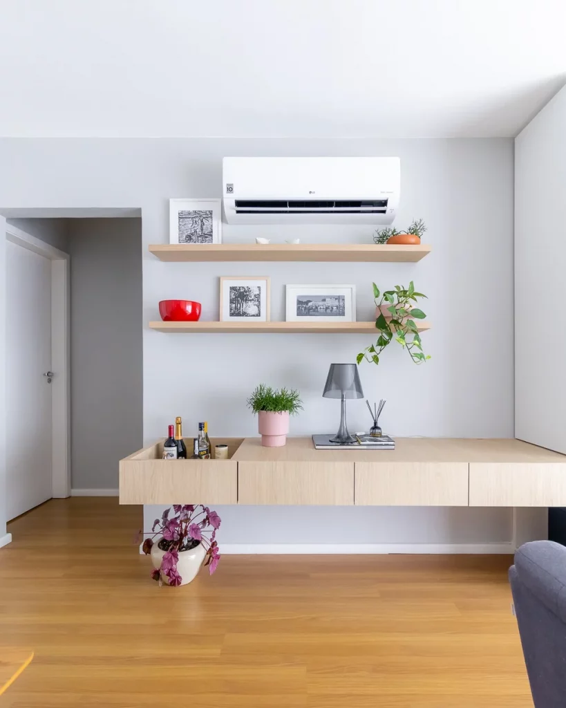 Rack suspenso de madeira com vaso e abajur em cima, prateleiras na parede.