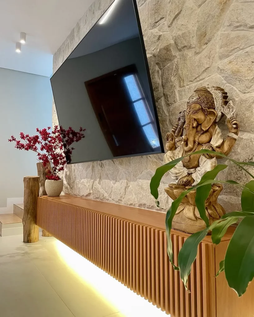 Rack suspenso com estátua dourada e flores rosa em cima.